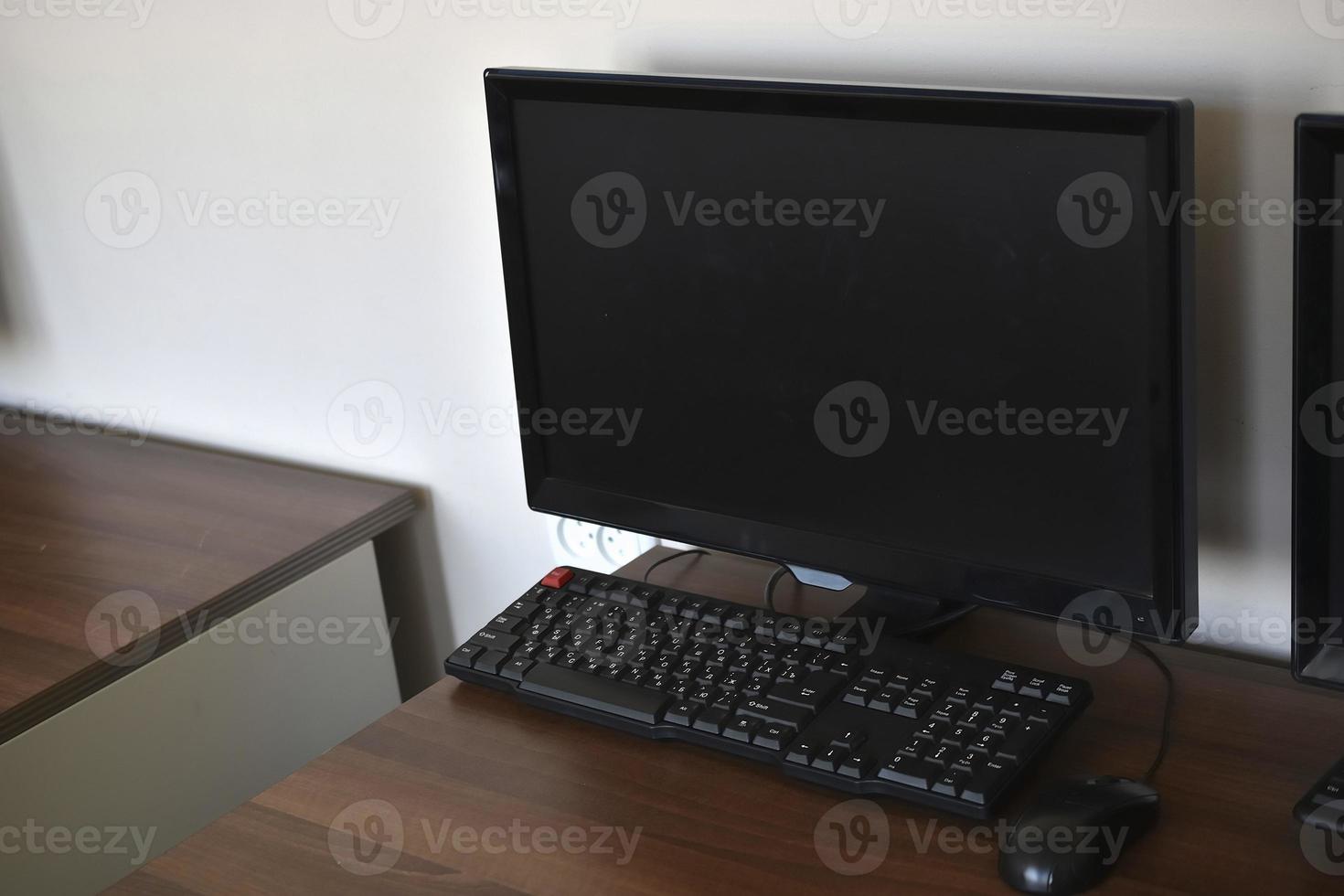 computador pessoal na mesa do escritório. monitore o teclado e o mouse em cima da mesa. foto