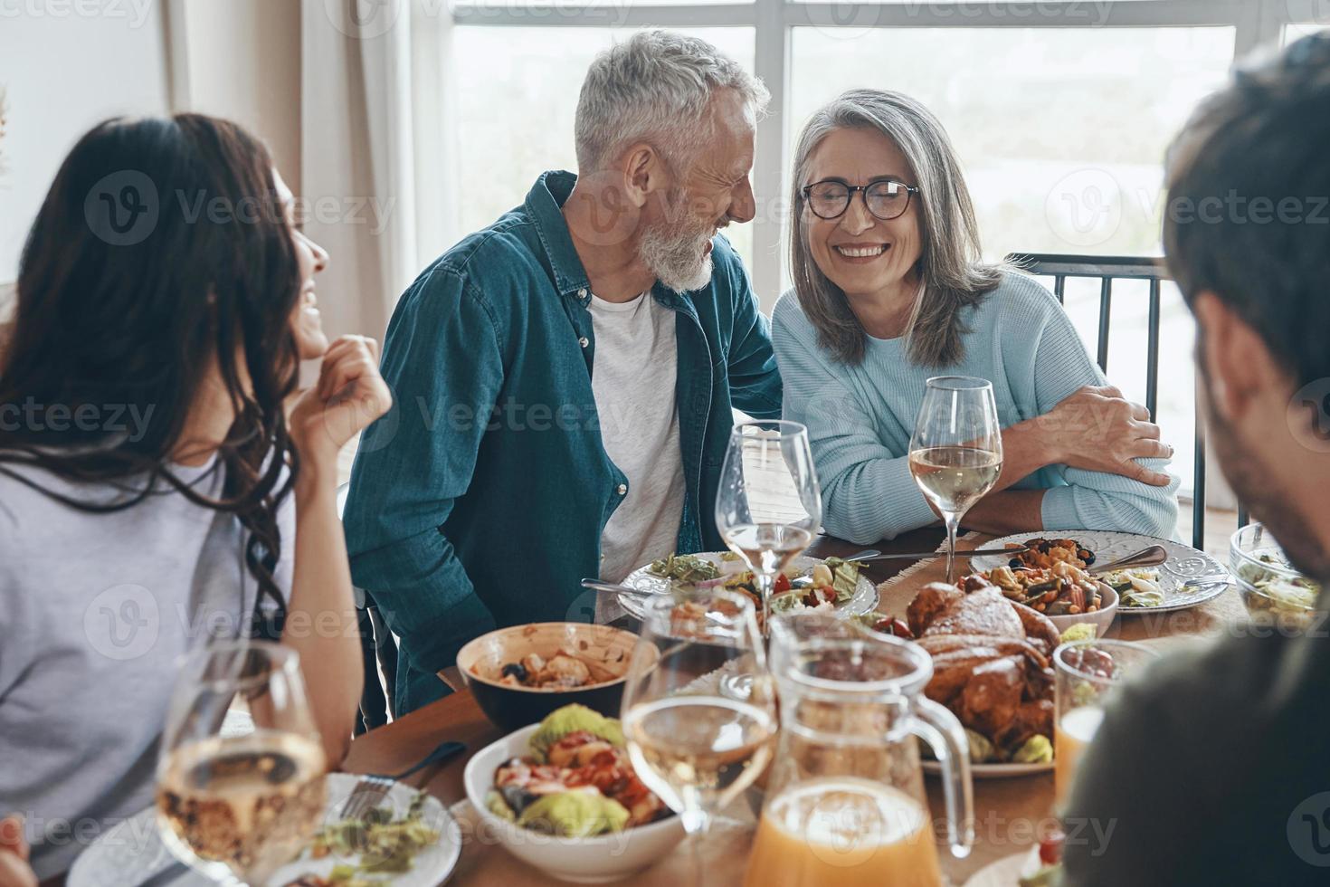 feliz família de várias gerações se comunicando e sorrindo enquanto jantava juntos foto