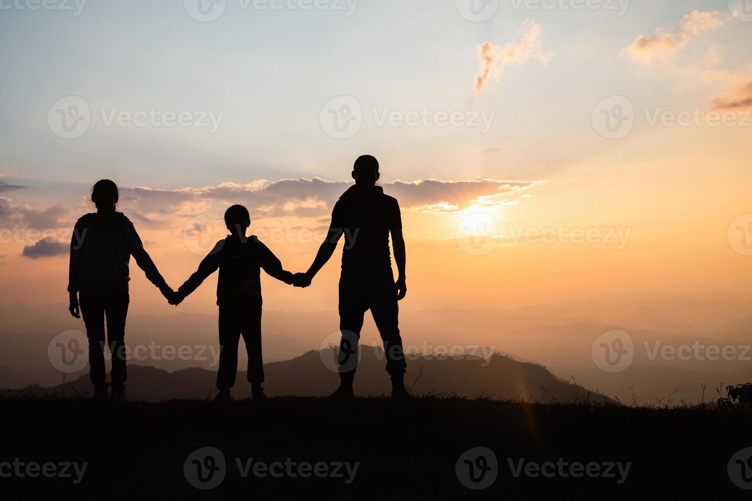 família feliz. silhueta mãe pai e filho na natureza da montanha no pôr do sol. foto