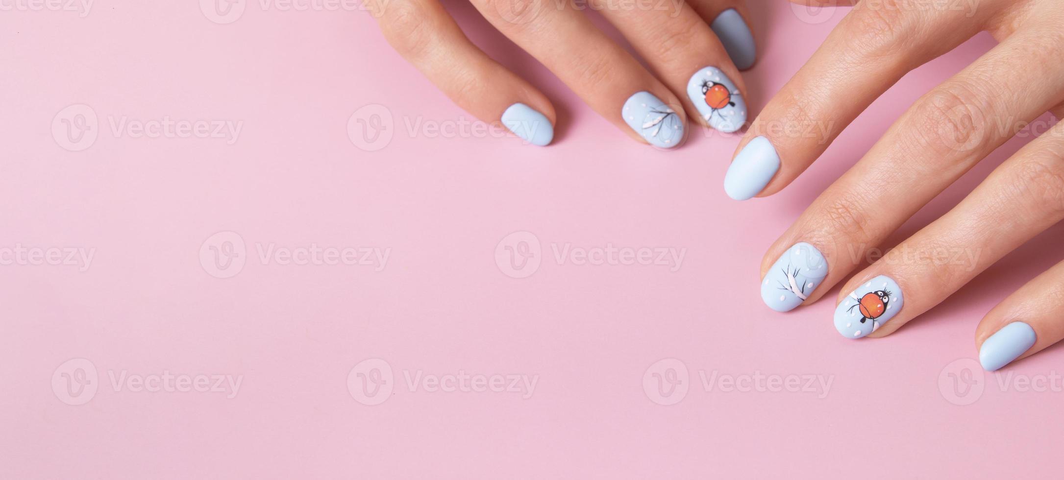 banner com mãos femininas com manicure de neve de inverno com adesivos sob um top fosco em fundo rosa foto