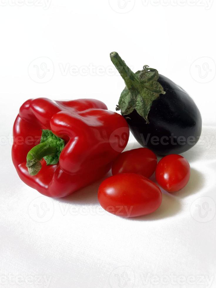pimenta vermelha, berinjela e tomate cereja em fundo branco foto