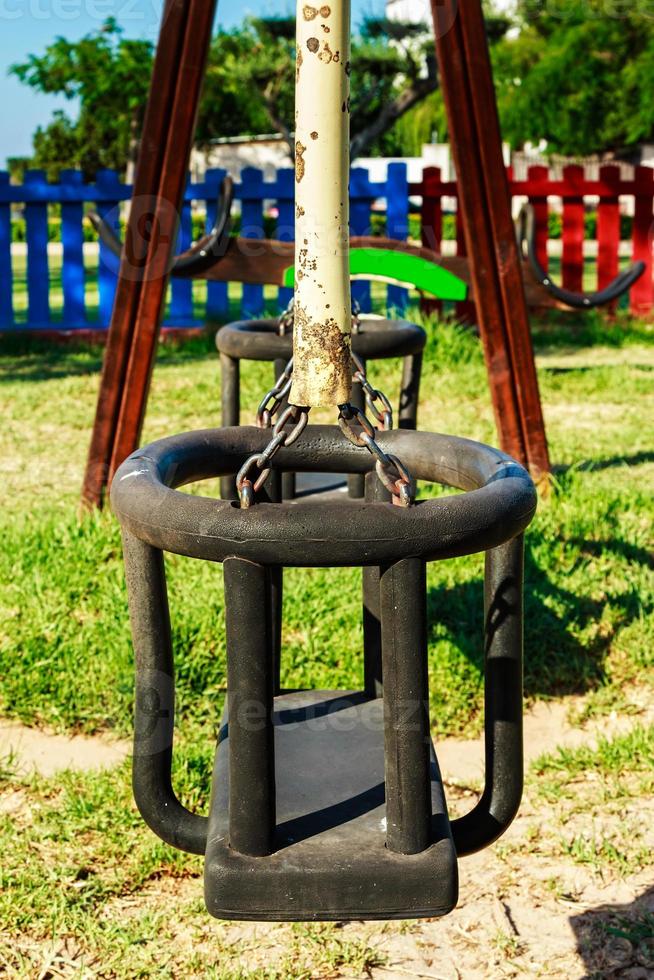 balançar no playground com cercas coloridas ao fundo. imagem vertical. foto