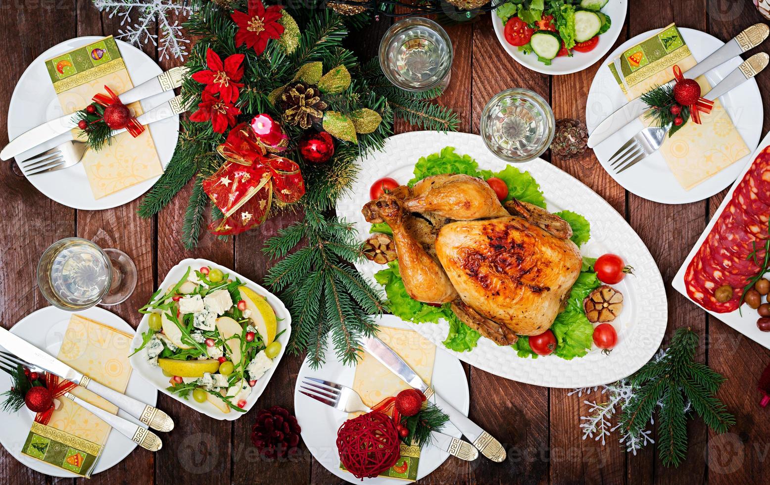 peru ou frango assado. a mesa de natal é servida com um peru, decorado com enfeites brilhantes e velas. frango frito, mesa. ceia de Natal. postura plana. vista do topo foto