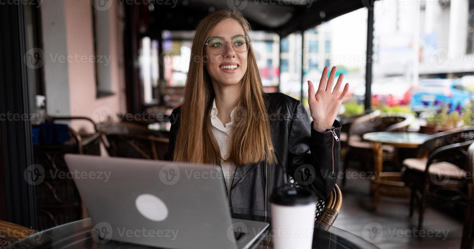 jovem estudante trabalhando online em um café em um laptop com uma xícara de café foto