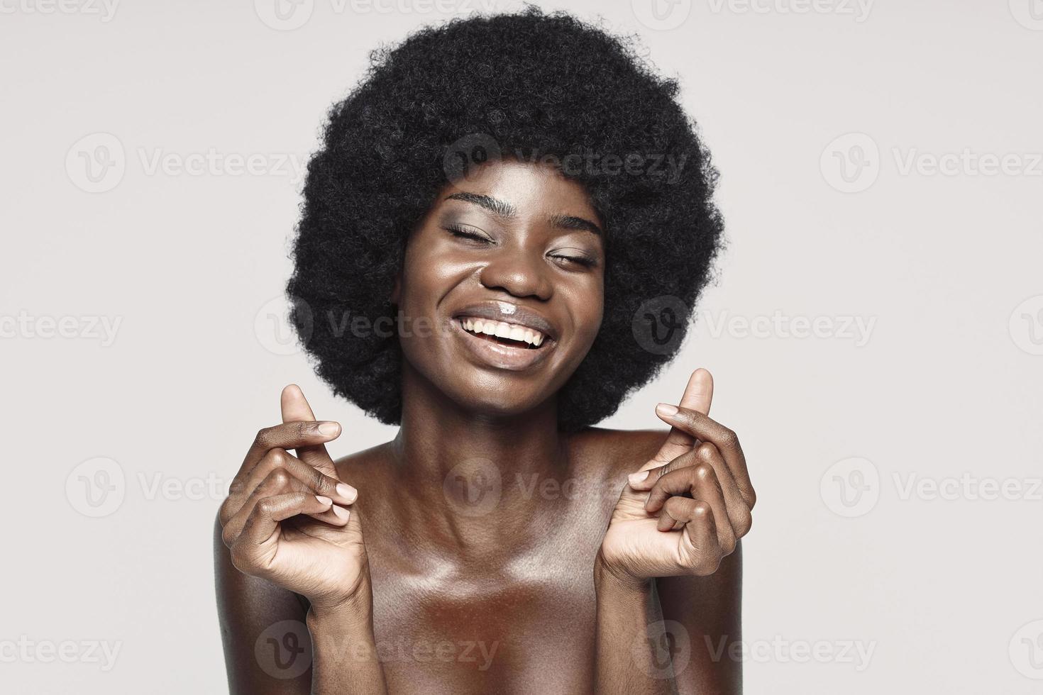 retrato de uma bela jovem africana, mantendo os olhos fechados e sorrindo foto