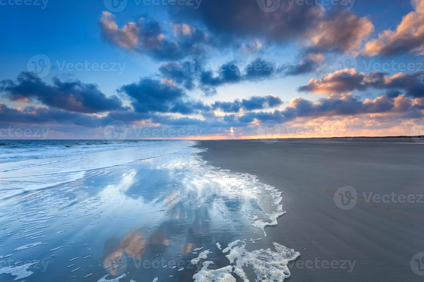 Cloudscape refletida no mar ao nascer do sol foto