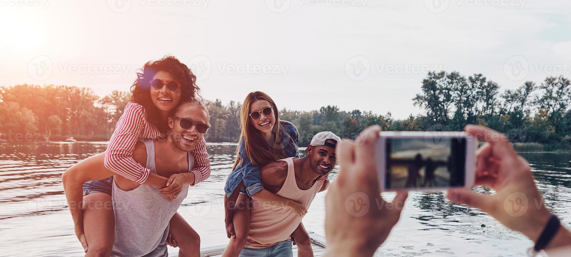 belo tiro belos casais jovens passando tempo despreocupado em pé no cais foto