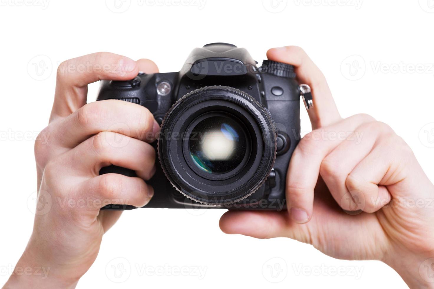 câmera digital. close-up do homem segurando a câmera digital enquanto isolado no branco foto