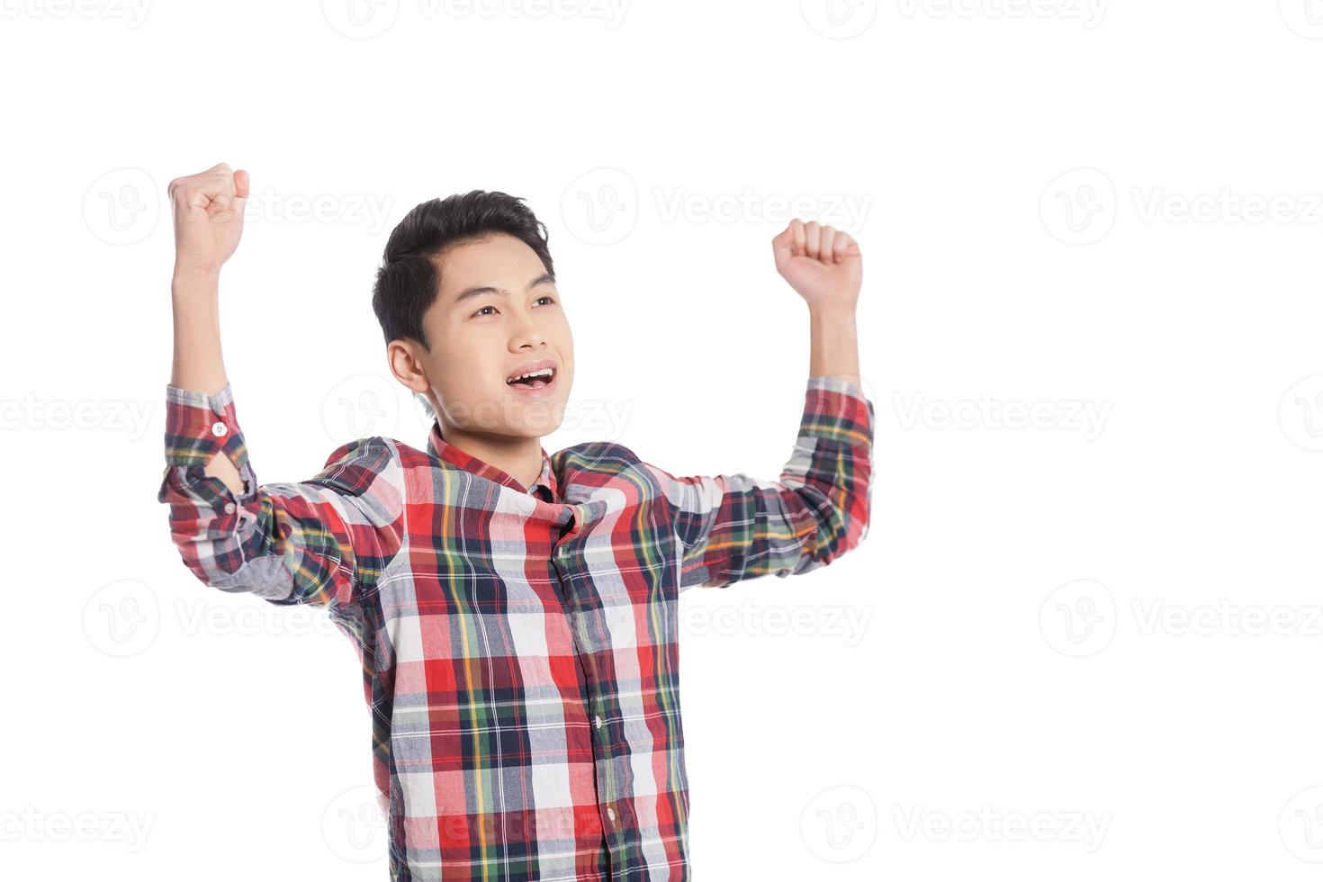 estou feliz sorrindo adolescente chinês mantendo os braços levantados em pé isolado no branco foto