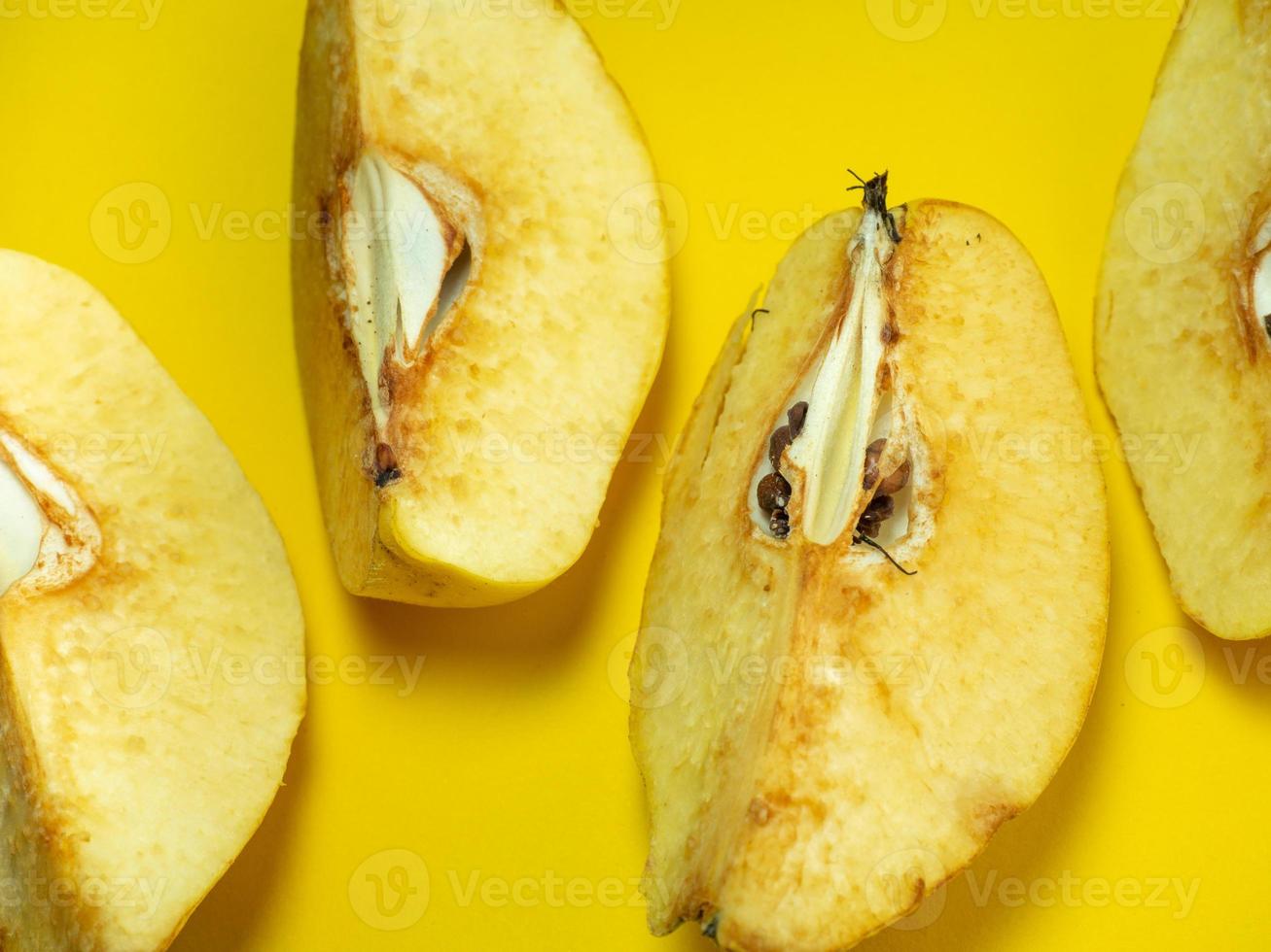 marmelo picado. frutas suculentas em um fundo amarelo. produto útil maduro. quartos de frutas. polpa de fruta intemperizada. escurecimento da fruta cortada foto