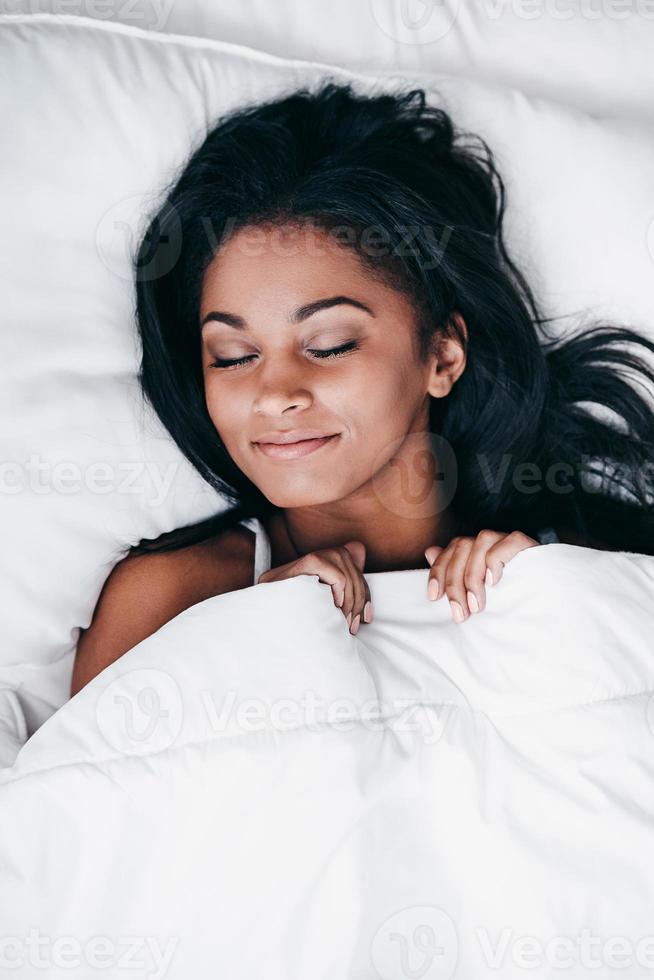 Beauty in bed. Top view close-up of beautiful young African woman in black  lingerie lying in bed and looking at camera 13576603 Stock Photo at Vecteezy