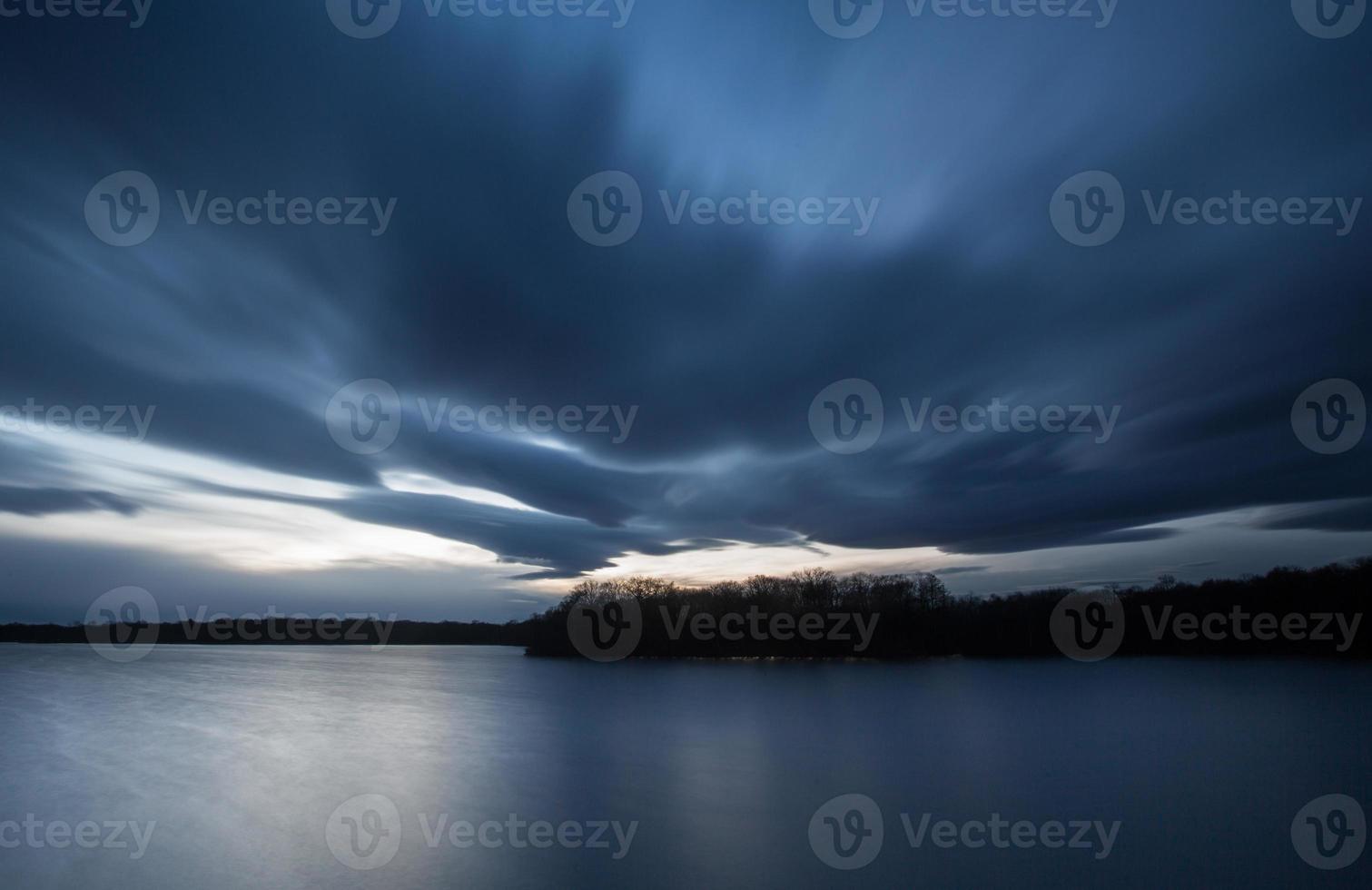 nuvens pesadas acima do lago foto