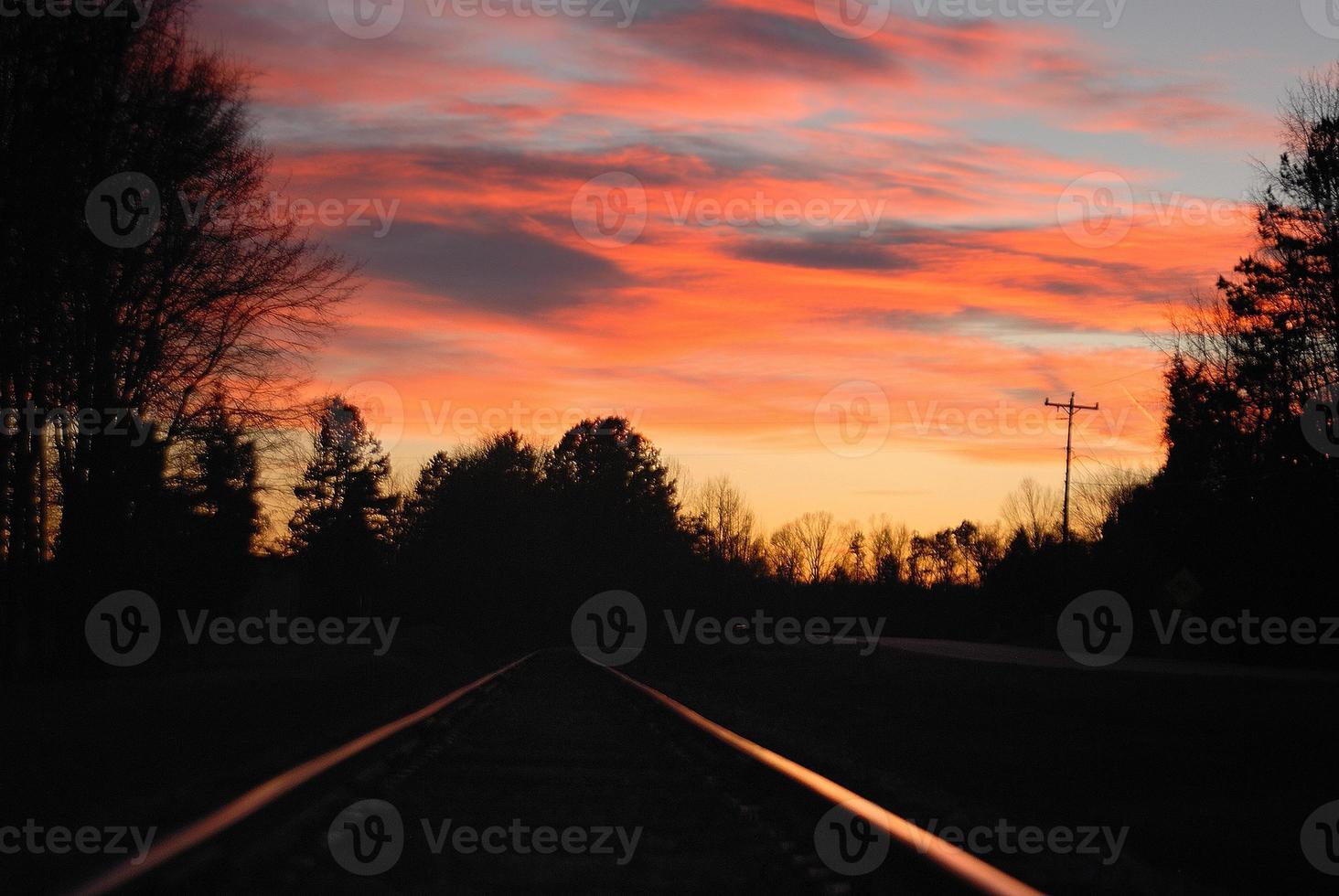reflexos do pôr do sol nos trilhos da ferrovia foto