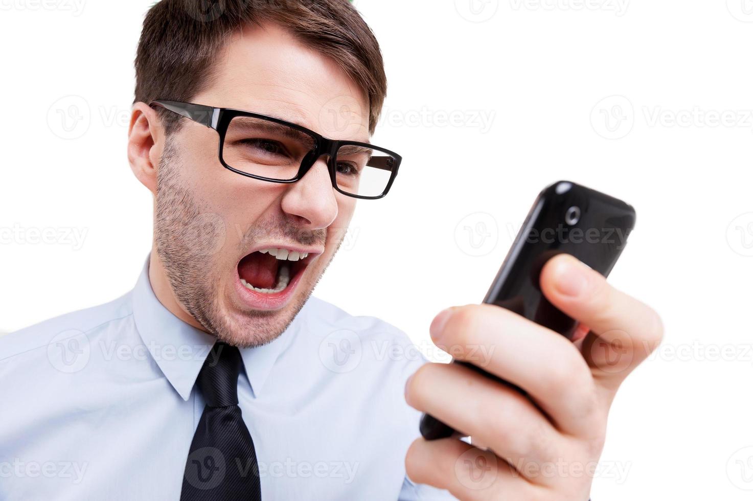 que dia estressante jovem furioso de camisa e gravata gritando no celular em pé isolado no branco foto