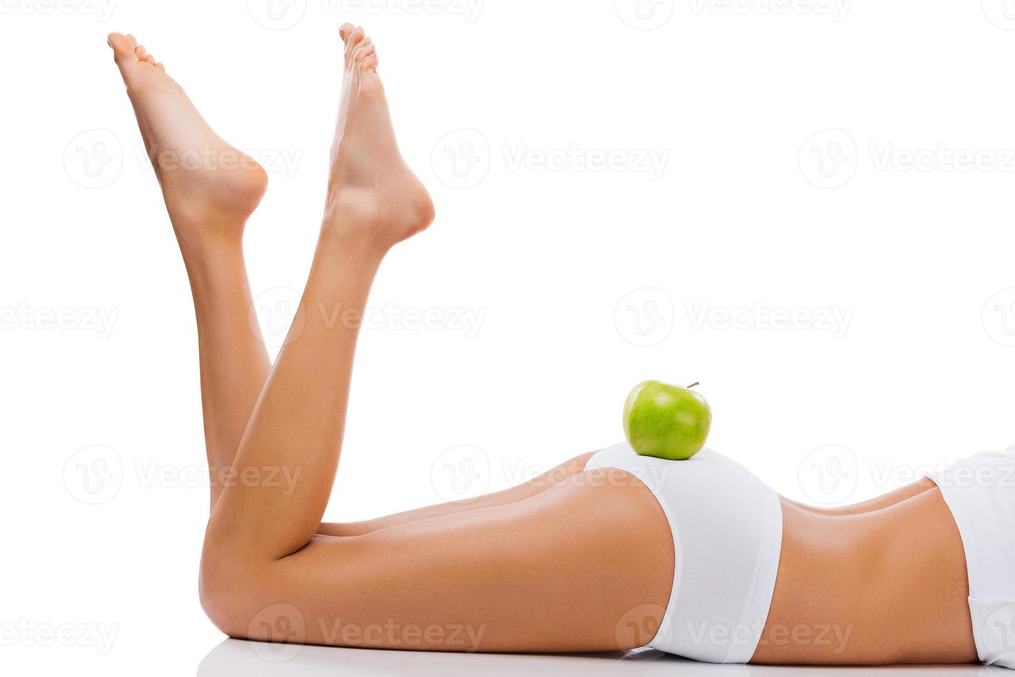 alimentação saudável para corpo saudável. foto recortada de uma bela jovem deitada contra um fundo branco