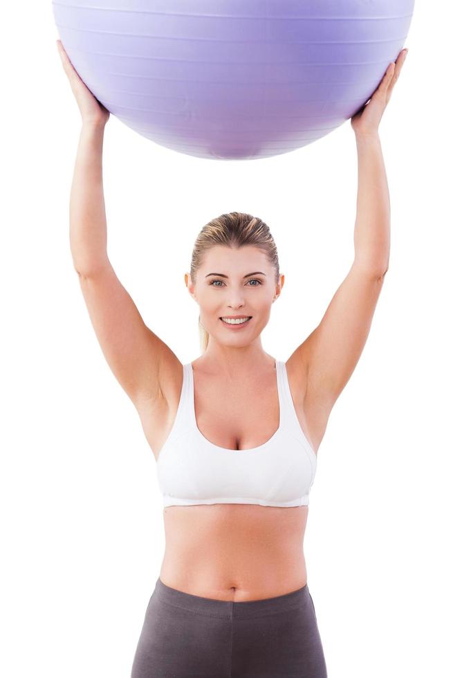 mulher com bola de fitness. mulher madura atraente segurando uma bola de fitness e sorrindo para a câmera foto