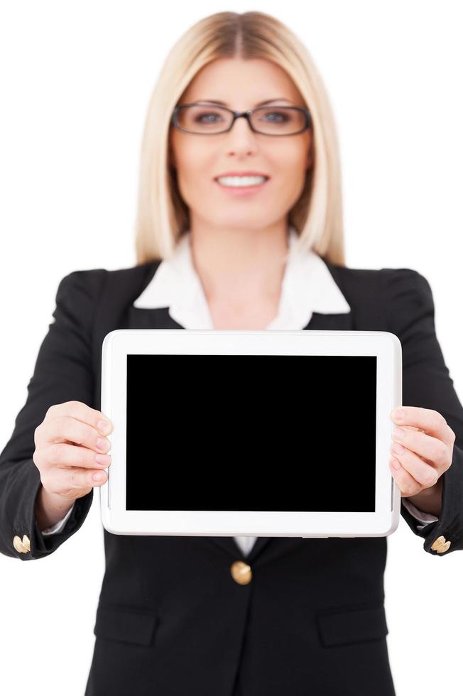 copie o espaço em seu tablet. imagem recortada de empresária madura mostrando seu tablet digital em pé isolado no branco foto