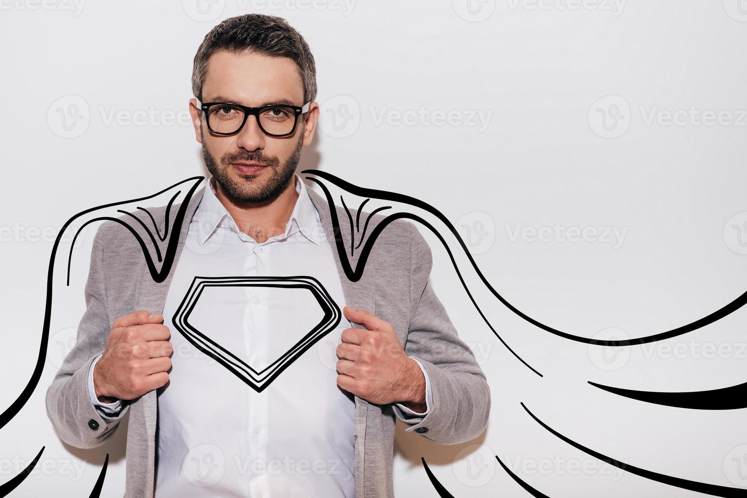 como um herói. jovem confiante ajustando sua jaqueta e parecendo super-herói em sua capa desenhada em pé contra um fundo branco foto