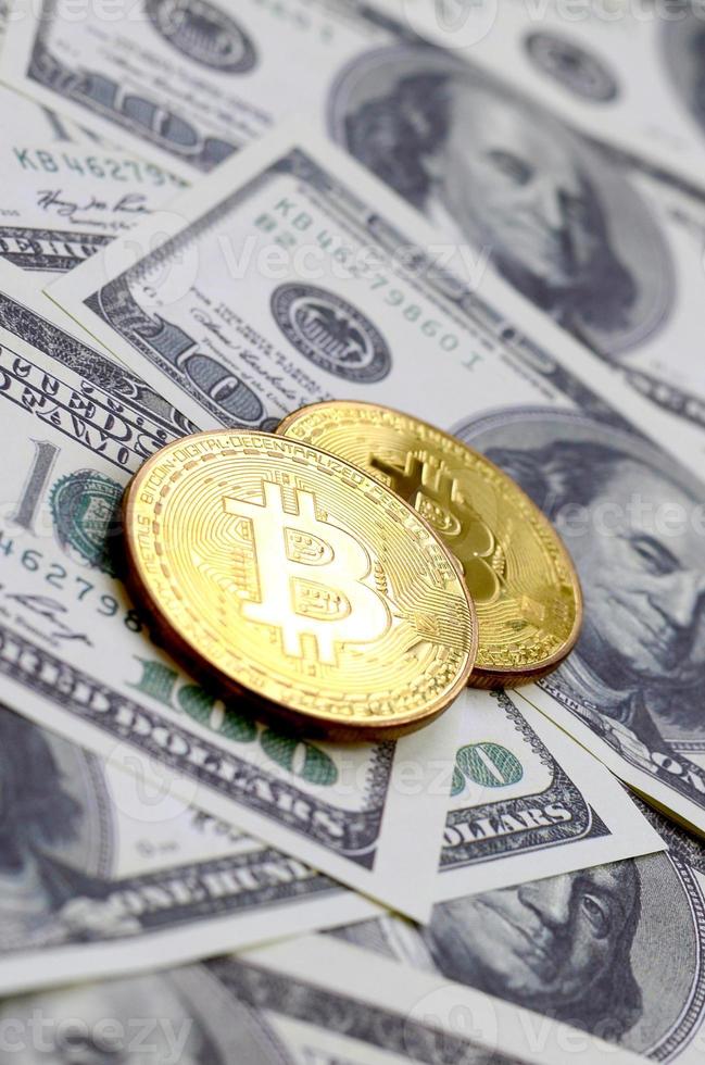 bitcoins dourados estão em muitas notas de dólar. o conceito de aumentar o preço do bitcoin em relação ao dólar americano foto