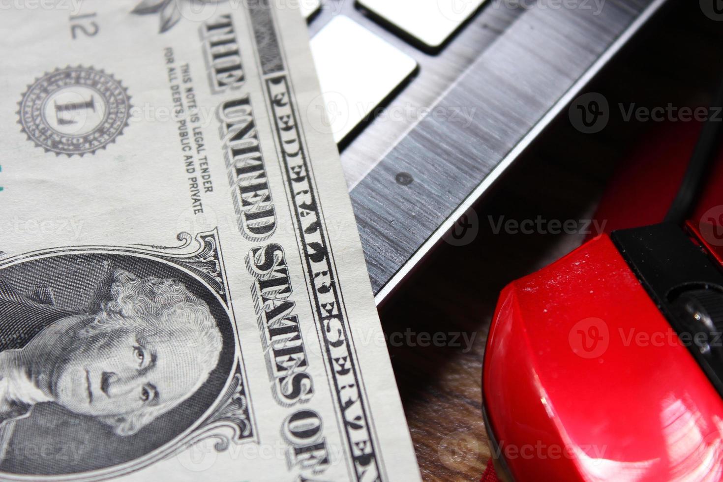 nota de dólar com computador portátil e mouse foto