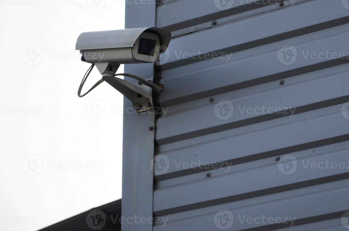 câmera de vigilância branca embutida na parede de metal do prédio de escritórios foto