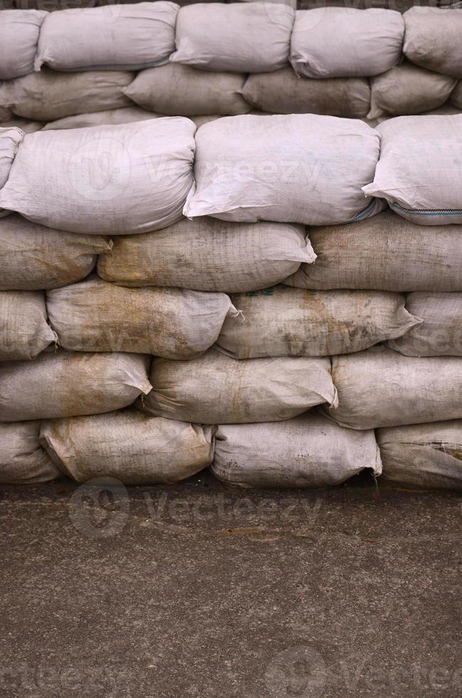 fundo de muitos sacos de areia sujos para defesa contra inundações. barricada protetora de sacos de areia para uso militar. belo bunker tático foto