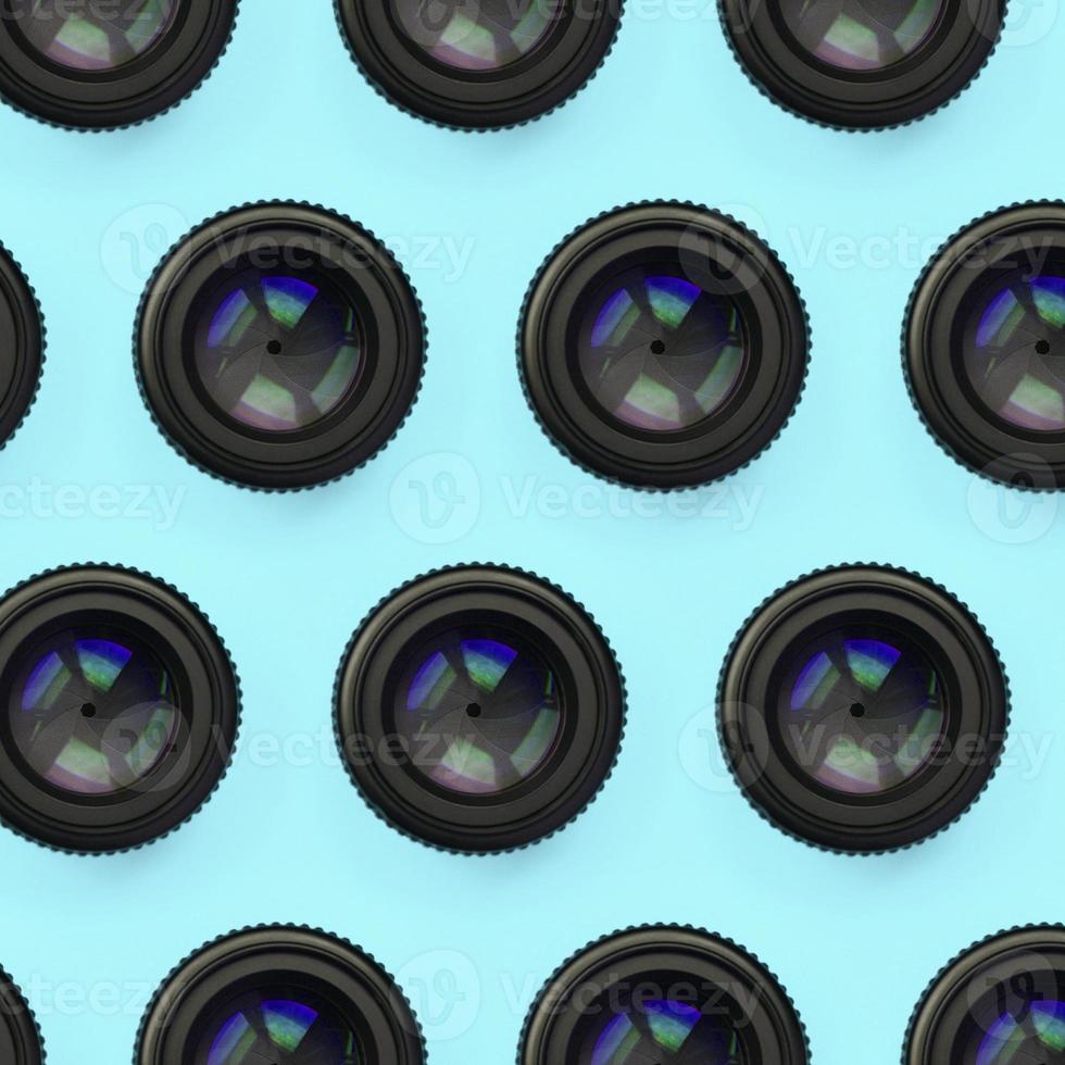 algumas lentes de câmera com uma abertura fechada estão no fundo da textura do papel de cor azul pastel de moda foto