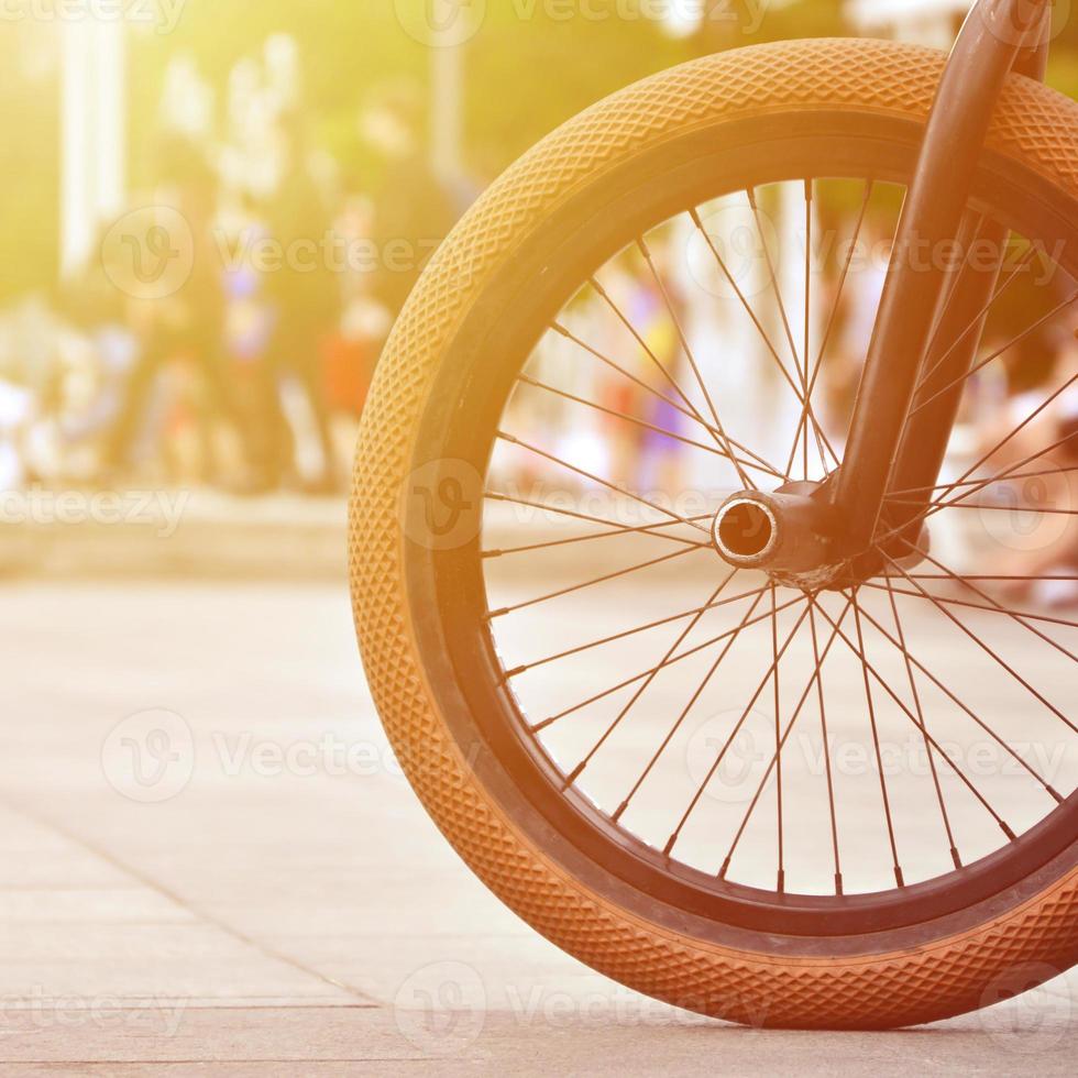 uma roda de bicicleta bmx no contexto de uma rua turva com ciclistas. conceito de esportes radicais foto