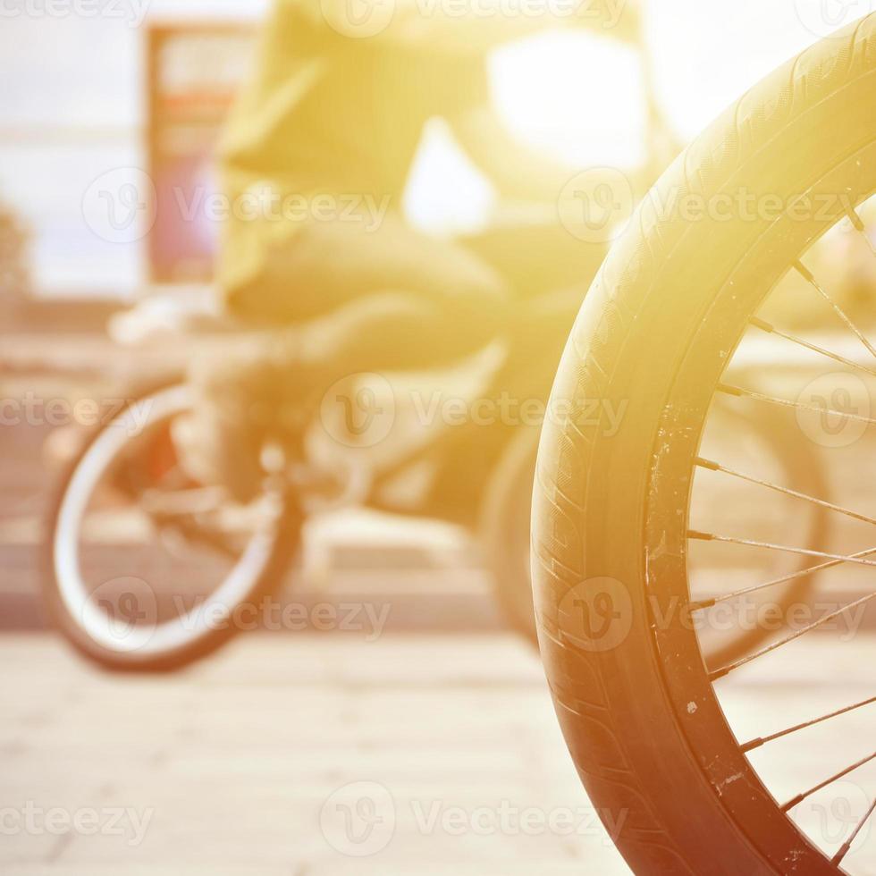 uma roda de bicicleta bmx no contexto de uma rua turva com ciclistas. conceito de esportes radicais foto