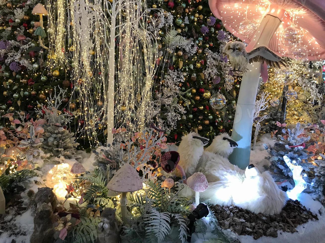decorações de Natal. um urso polar de brinquedo está sob um cogumelo colorido e move suas patas. ao lado dela estão cogumelos coloridos. brinquedos bonitos da véspera de natal para crianças foto