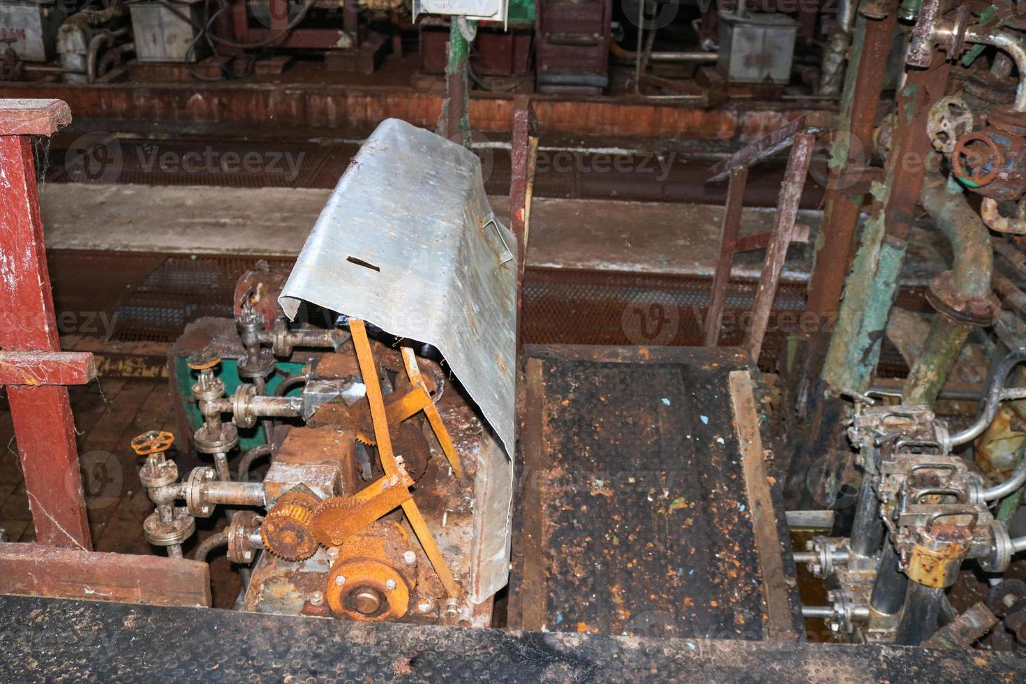 antiga loja de descascamento fechada enferrujada em uma refinaria de engenharia química petroquímica industrial abandonada obsoleta com tubos de ferro metálico de grandes flanges de equipamentos e bombas de mangueiras foto