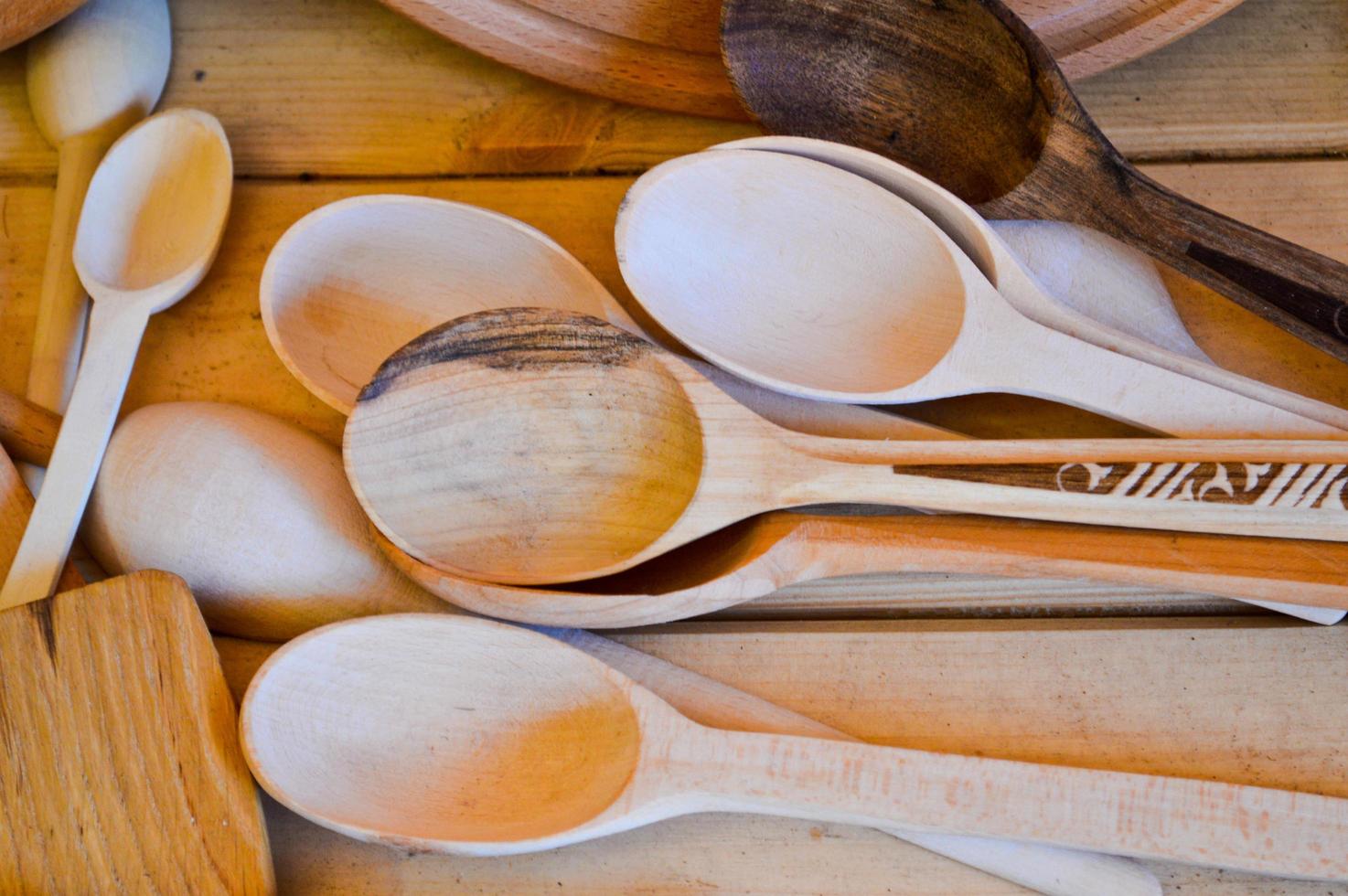 utensílios de cozinha tradicionais de madeira natural, pratos, colheres, pás. o fundo foto