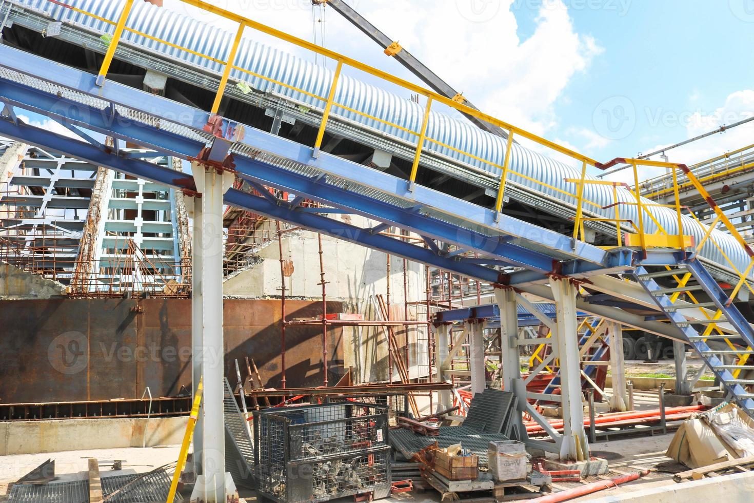 estruturas metálicas de ferro, produção industrial com transportador, tubos, trilhos e oleodutos na produção de uma planta petroquímica de refino de petróleo foto