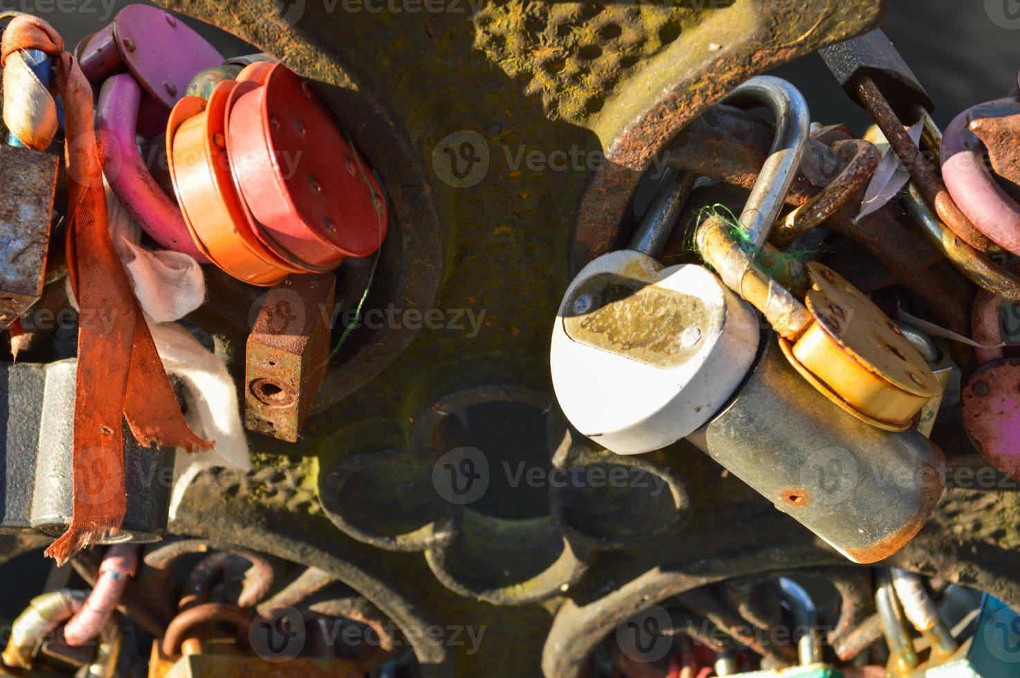 muitas fechaduras de celeiro penduradas no corrimão da ponte. tradição de casamento para pendurar cadeados em pontes para o amor eterno foto