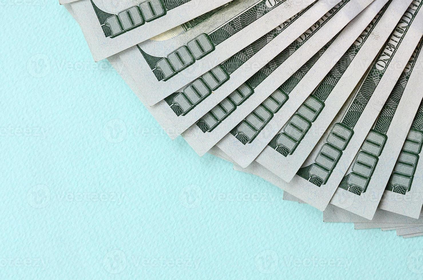 fã de notas de um dólar americano de um novo design encontra-se em um fundo azul claro foto
