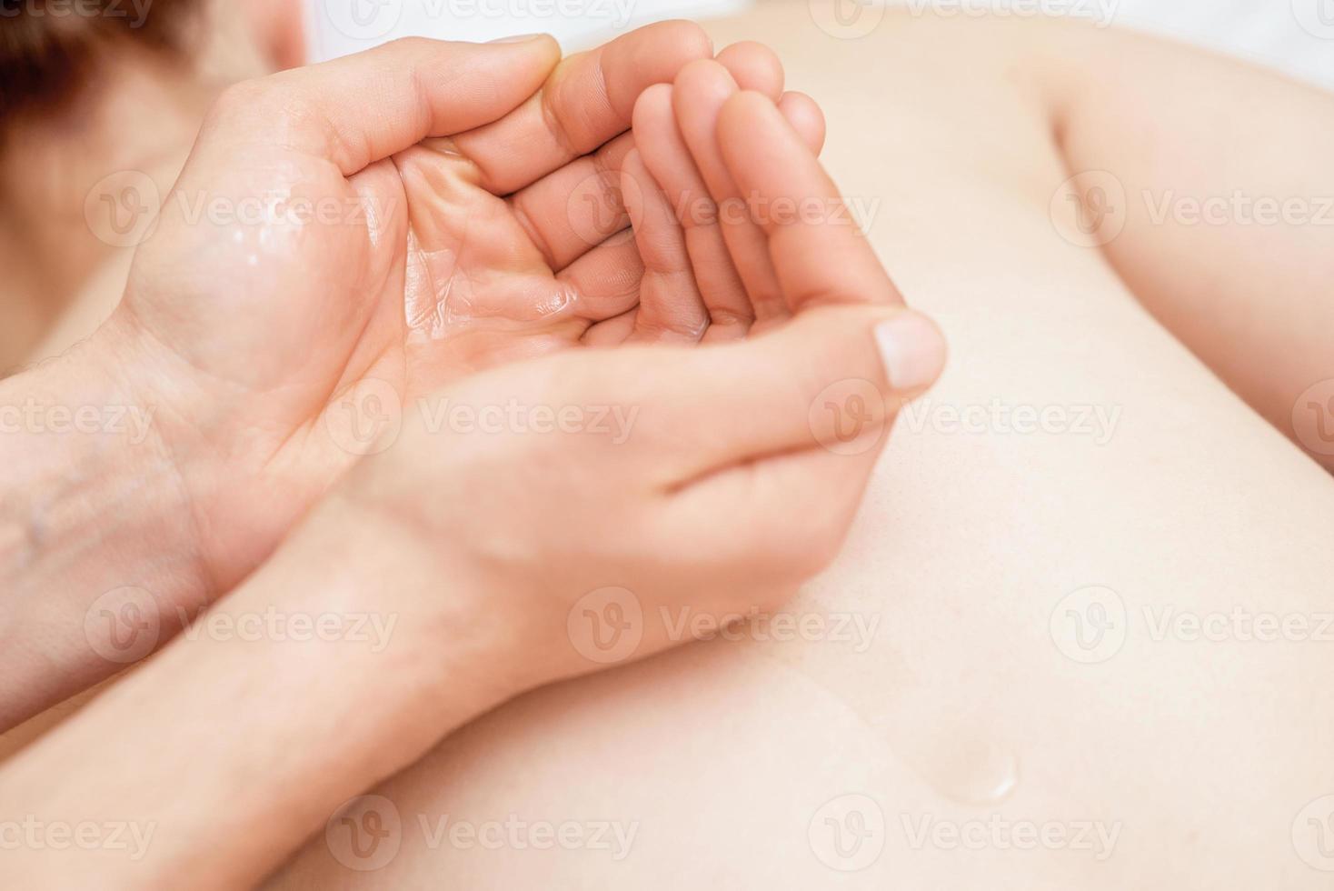 óleo de massagem nas palmas das mãos do massageador. foto
