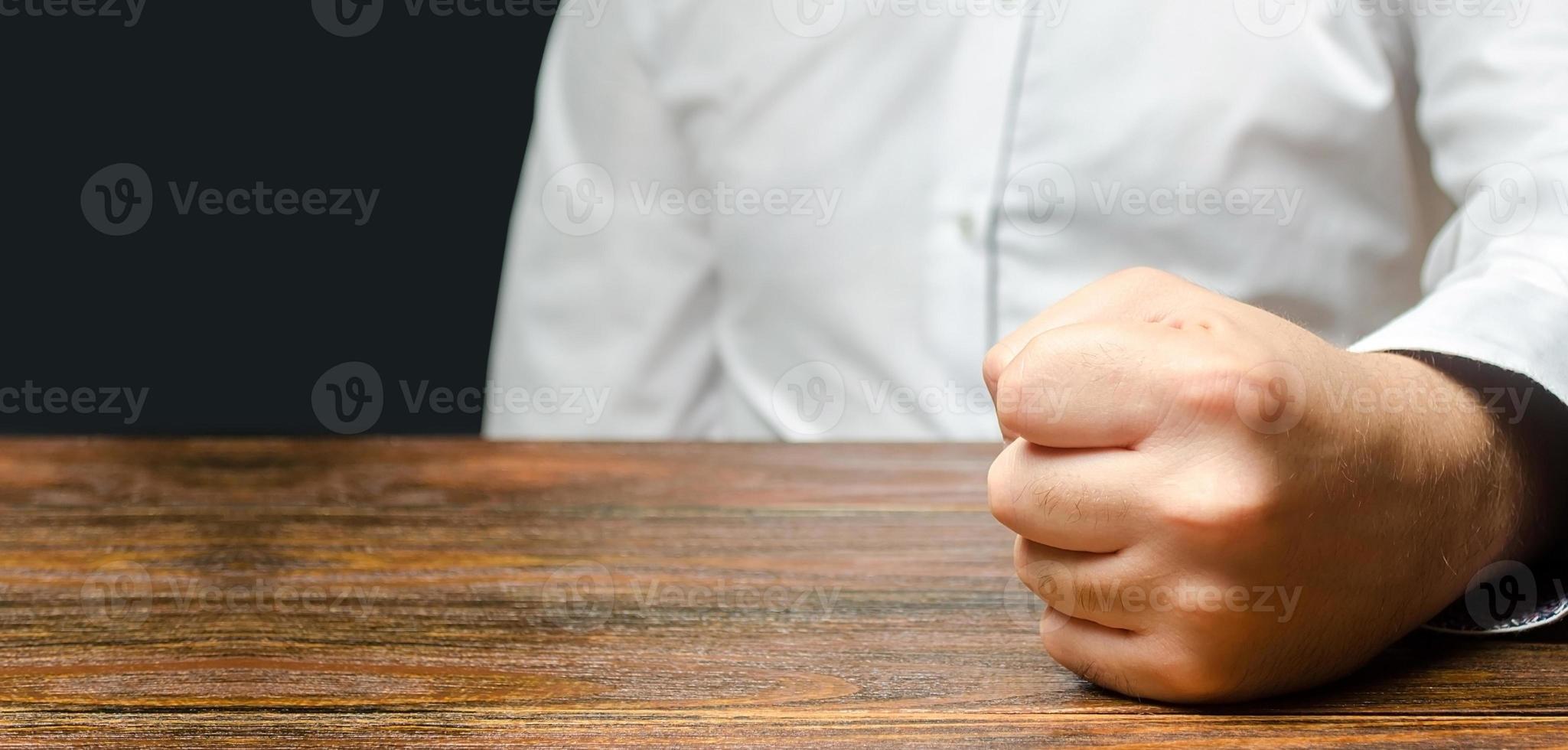 o homem atingido deu um soco na mesa. o fim da paciência. é impossível suportar. um ataque de raiva, estresse. um gesto decisivo e emocional. homens impulsivos. já chega de colérico foto