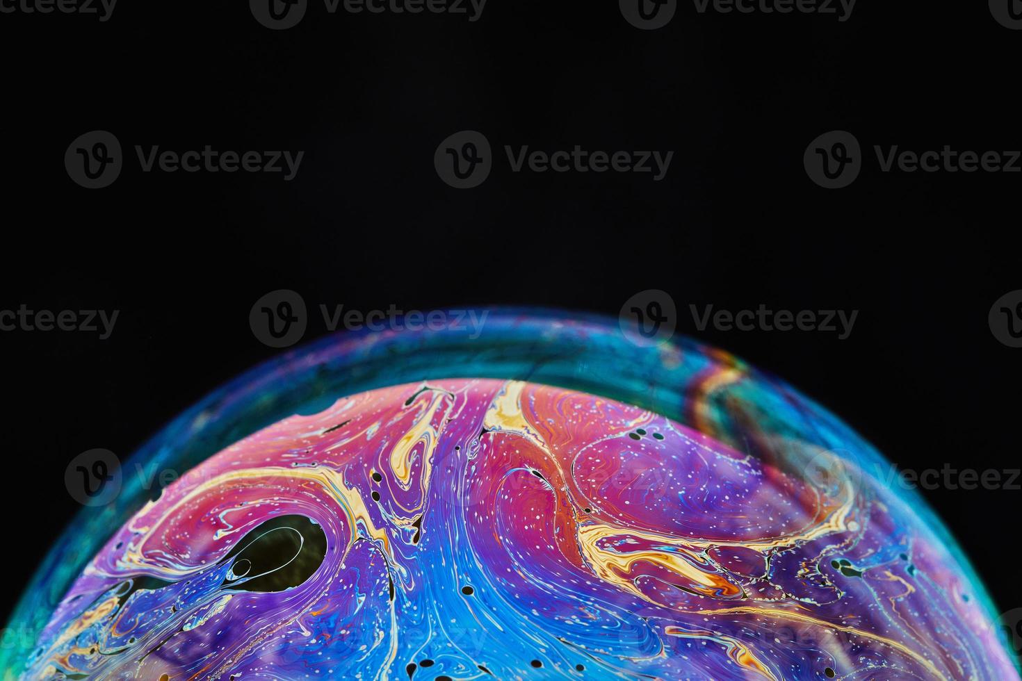 espaço de realidade virtual com planeta psicodélico multicolor abstrato. bolha de sabão closeup como um planeta alienígena em fundo preto foto
