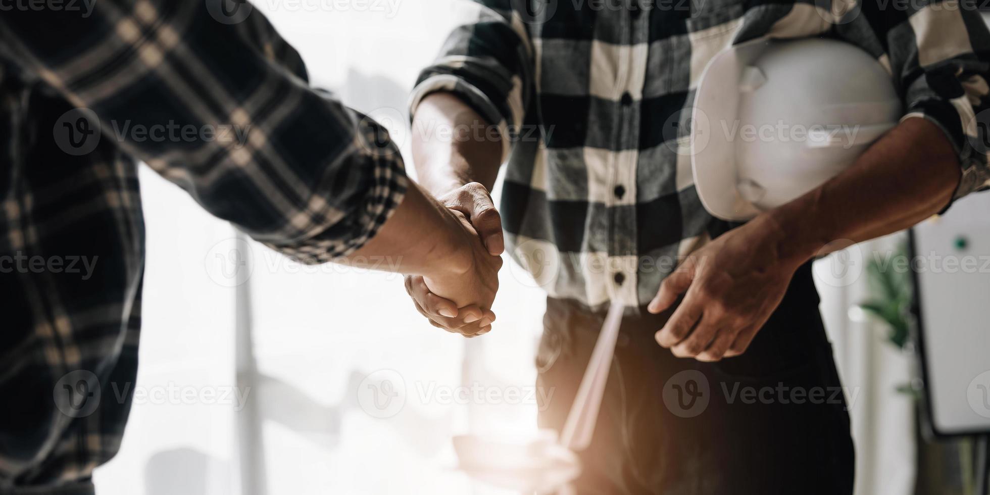 de mãos dadas entre empreiteiros de projetos e clientes devido à negociação de despesas e investimentos, construção e reparação de edifícios residenciais. foto