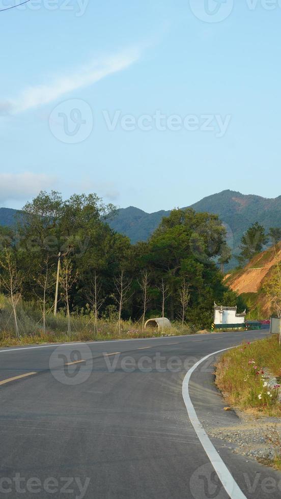 a bela vista do campo com a estrada e as montanhas como pano de fundo foto