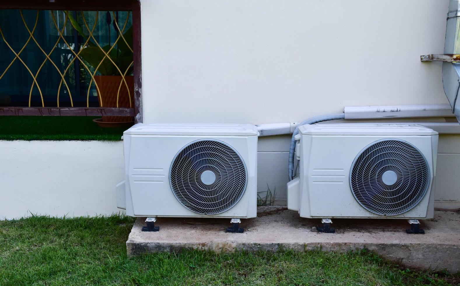 branco duas unidades de ventilador de condicionamento instalado no piso de cimento do prédio, foco suave e seletivo. foto