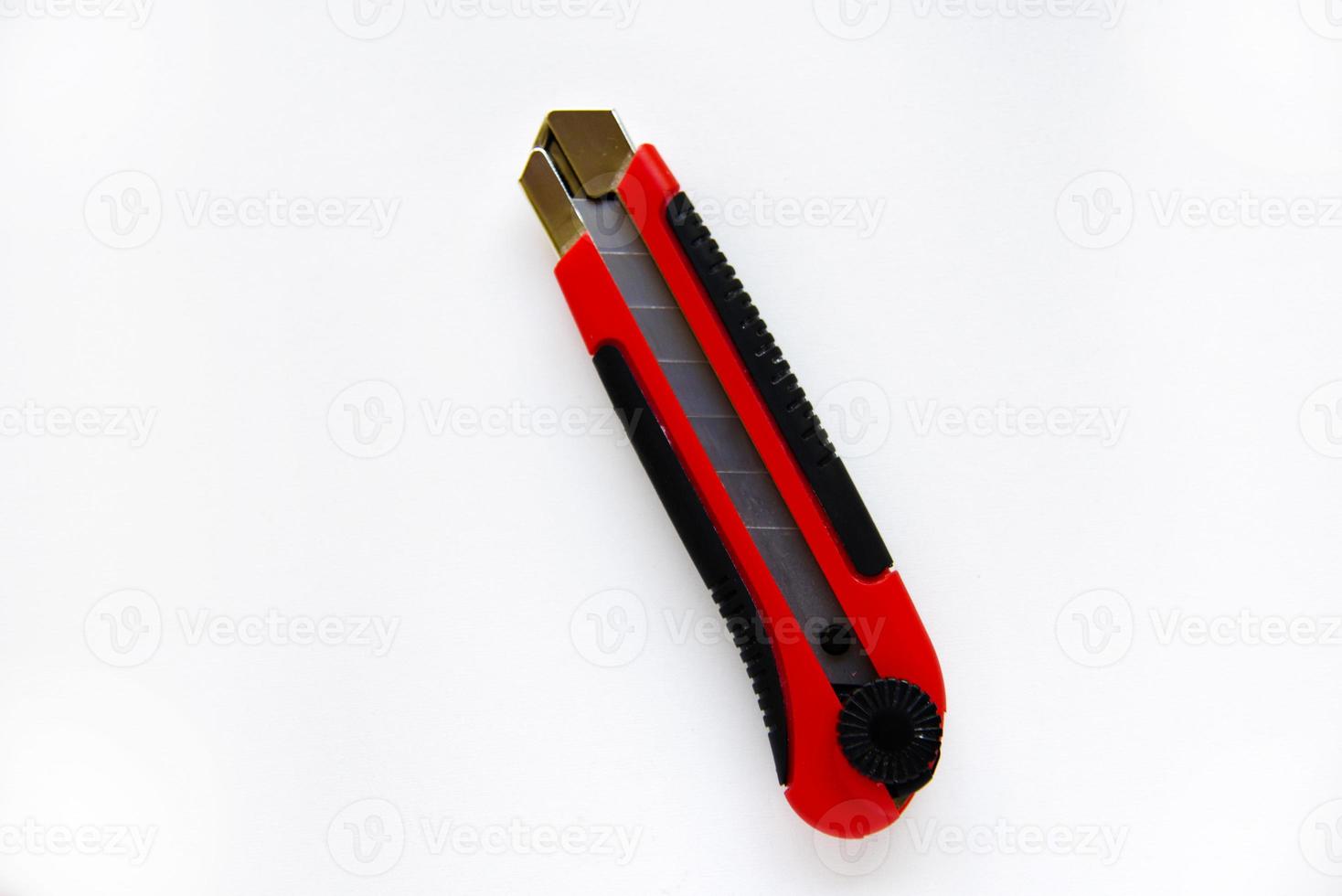 faca de papelaria vermelha com lâminas em um fundo branco. ferramenta de corte com lâminas em um fundo branco. foto
