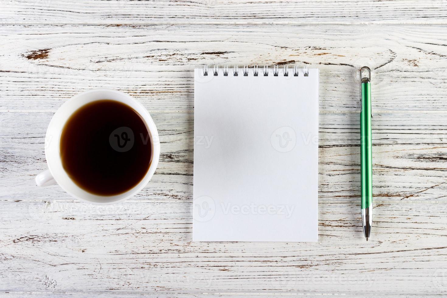 mesa de escritório com xícara de café e bloco de notas foto