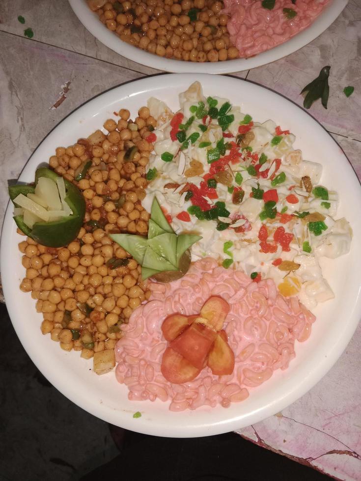 prato de salada com uma combinação de milho, salada de espaguete e salada russa foto