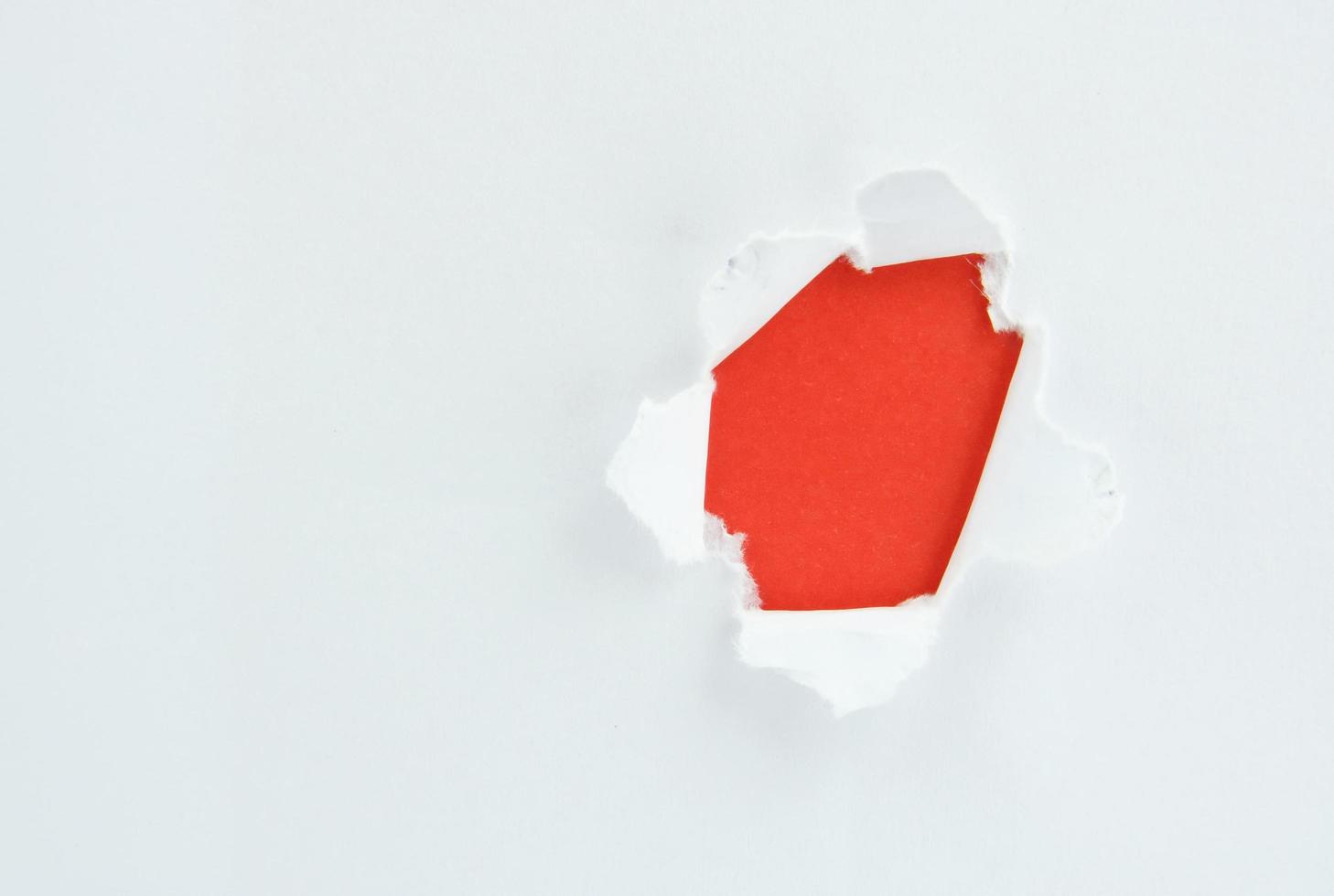 papel branco rasgado contra um fundo vermelho foto
