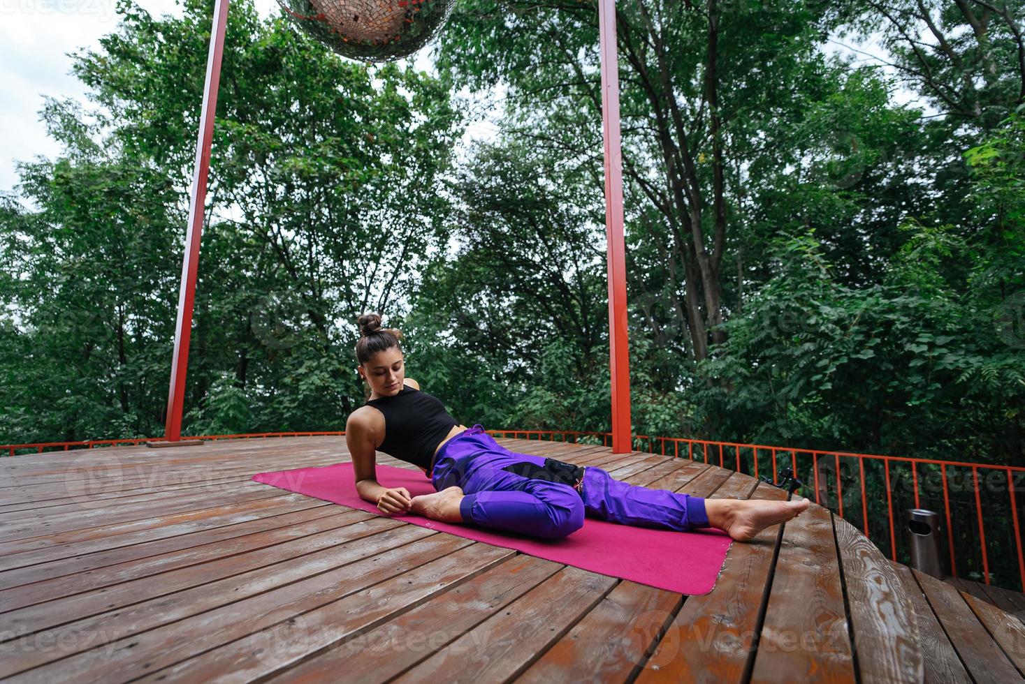 jovem mulher bonita fazendo exercícios de fitness deitada de costas foto