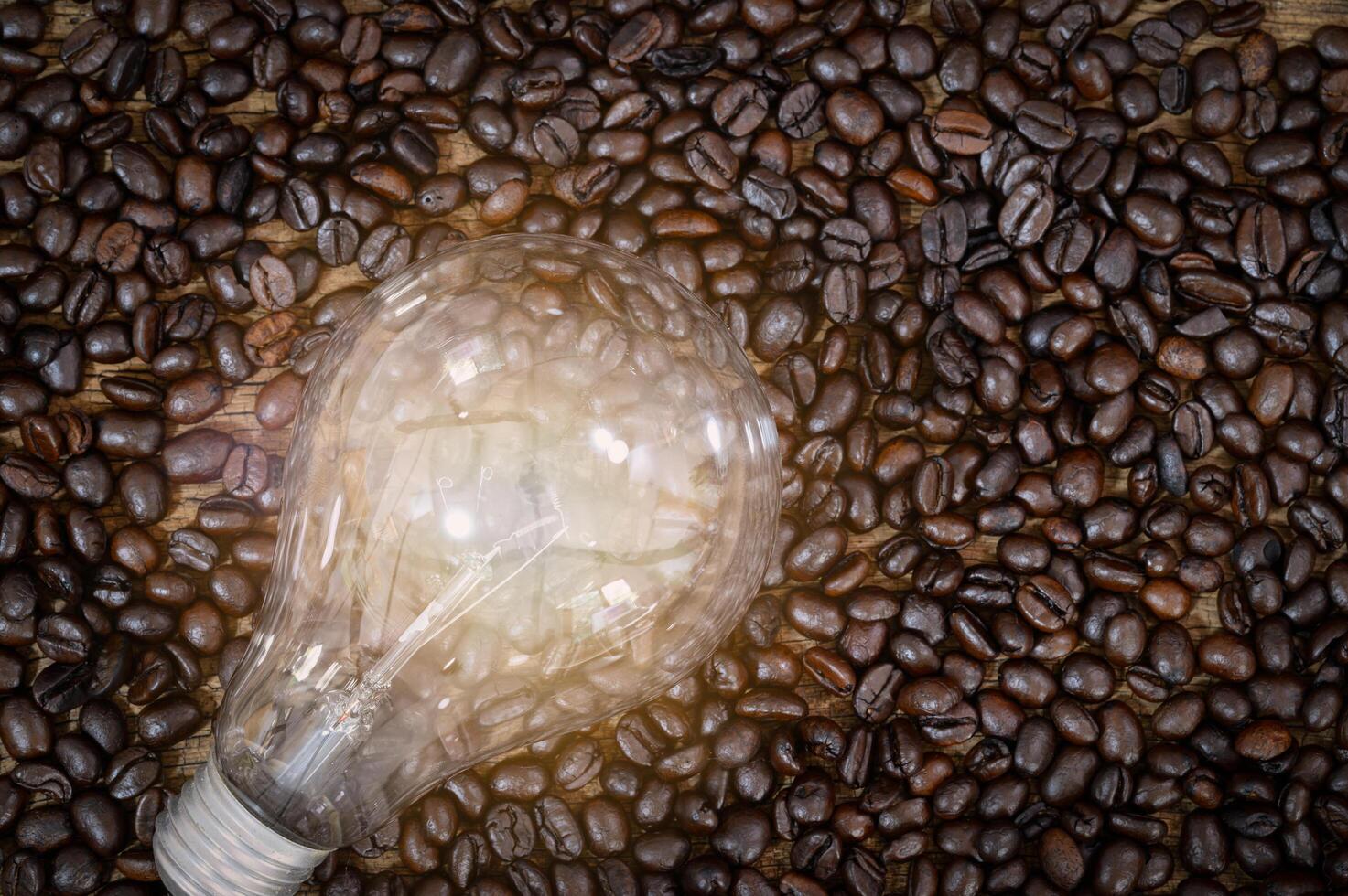 lâmpada brilhando sobre os grãos de café foto