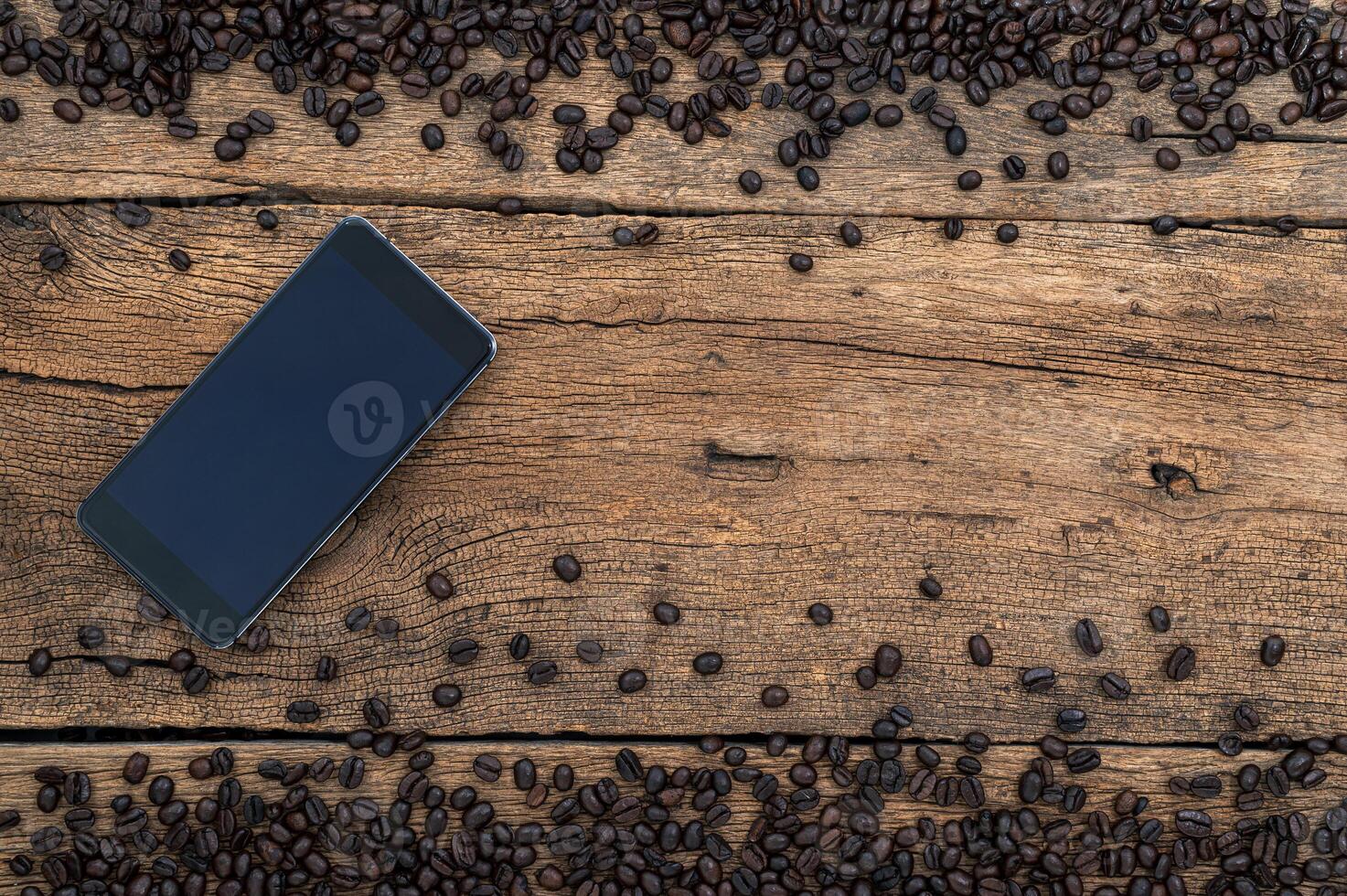 smartphone e grãos de café na mesa foto