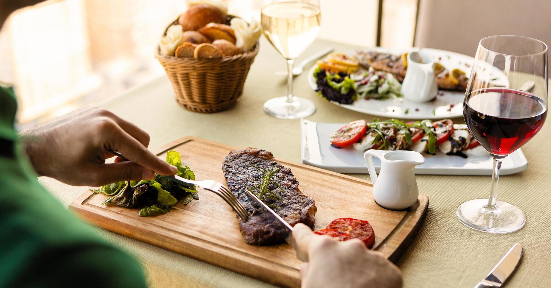 homem cortando um bife foto