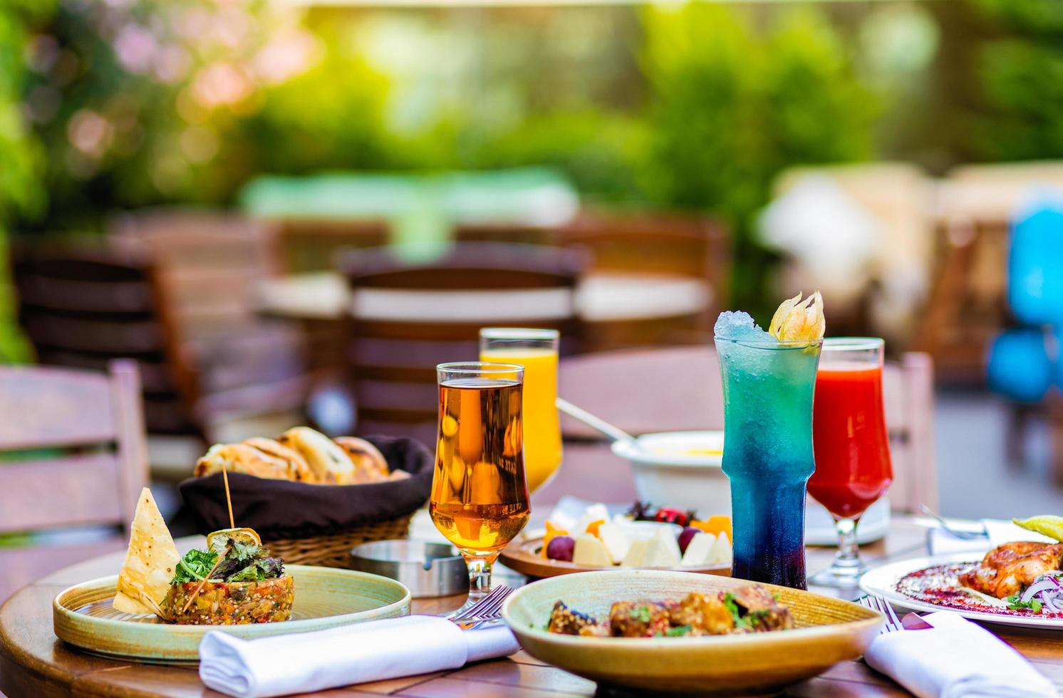 refeições variadas na mesa de madeira do terraço foto